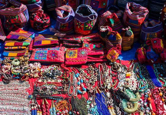 gettyimages-463223893-612×612 ANJUNA, GOA, INDIA - 2013/12/18: Many different goods like artfully designed bags and colorful jewellery are presented for sale at the weekly flea-market. (Photo by Frank Bienewald/LightRocket via Getty Images)